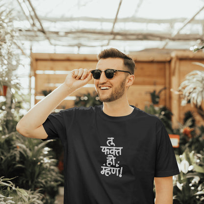  A man wearing a black t-shirt and sunglasses  with "tu fakt ho mhan" printed on it, smiling at the camera.