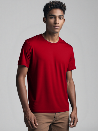 A man wearing a red t-shirt stands confidently, showcasing a casual and relaxed style.